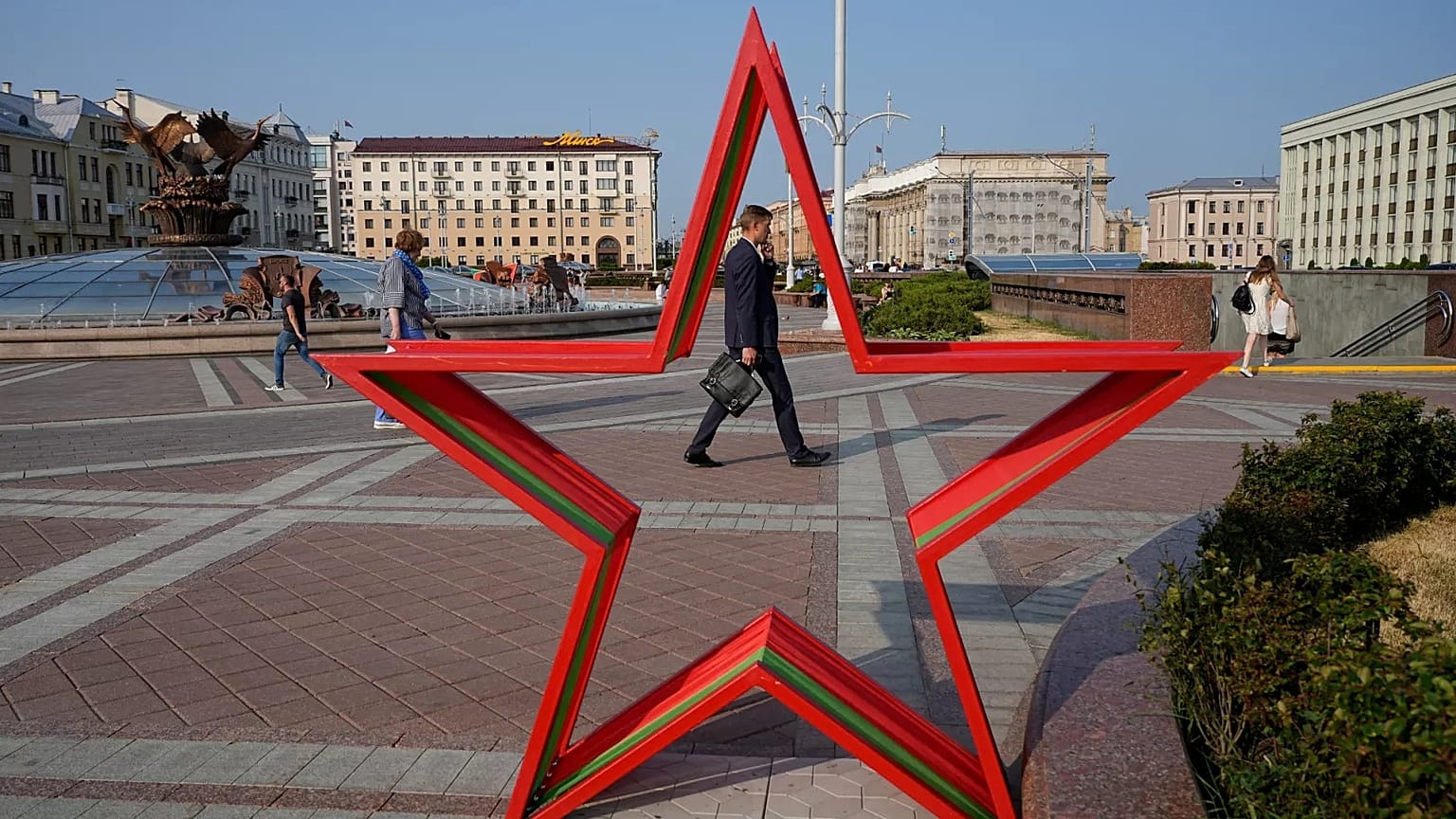 People walk in Independent Square during sunset in Minsk, 5 July, 2023