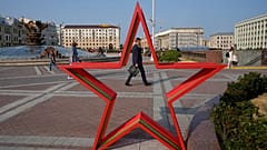 Menschen spazieren bei Sonnenuntergang auf dem Platz der Unabhängigkeit in Minsk, 5. Juli 2023
