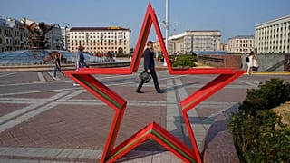 People walk in Independent Square during sunset in Minsk, 5 July, 2023