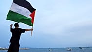 متظاهر يلوح بعلم فلسطيني لدعم أسطول الصمود العالمي عند وصوله إلى ميناء سيدي بوسعد في تونس العاصمة ، تونس ، الأحد ، سبتمبر. 7, 2025. 