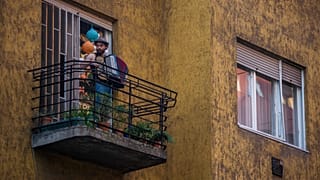 Иллюстрационное фото. Венгерский музыкан Адам Мозер играет на аккордеоне с балкона в Будапеште. Март 2020   