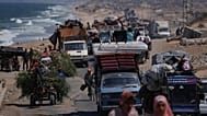 Displaced Palestinians fleeing northern Gaza carry their belongings along the coastal road toward southern Gaza, 9 September, 2025