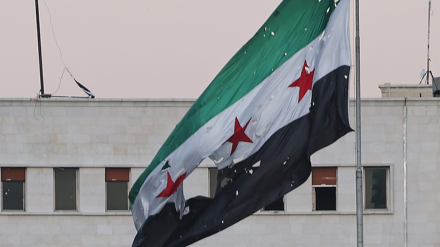 يرفرف علم سوري ممزق فوق مبنى وزارة الدفاع السورية، دمشق، سوريا، الأربعاء 16 تموز/يوليو 2025.