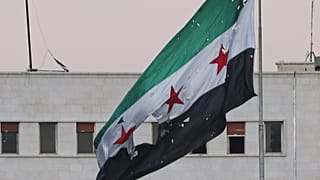 يرفرف علم سوري ممزق فوق مبنى وزارة الدفاع السورية، دمشق، سوريا، الأربعاء 16 تموز/يوليو 2025.