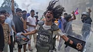 Un manifestant portant un gilet pare-balles et un bouclier arraché à un policier crie des slogans au Singha Durbar, lors d'une manifestation à Katmandou, Népal, le 9 septembre 2025