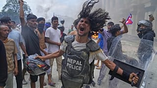 Un manifestante con giubbotto antiproiettile e scudo sottratto a un poliziotto grida slogan al Singha Durbar, durante una protesta a Kathmandu, Nepal, il 9 settembre 2025