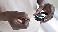 A woman uses a paper strip to test her blood sugar levels.