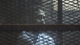 الناشط المصري البارز علاء عبد الفتاح يقف داخل قفص الاتهام وذلك داخل قاعة محكمة في القاهرة، مصر، في 23 فبراير 2015.