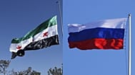 العلم الروسي (يمينًا) والعلم السوري (يسارًا)