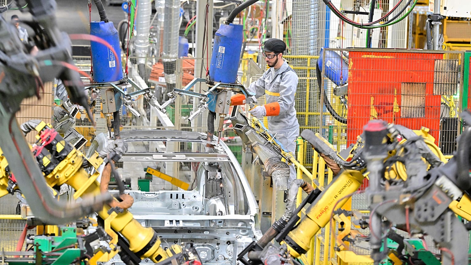 A worker assembles vehicle parts on a production line inside Renault factory.
