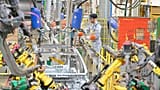 A worker assembles vehicle parts on a production line inside Renault factory.