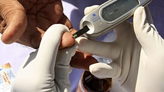 ممرضة تجمع عينة دم من مريض خلال حملة فحص مجاني للسكري في حيدر أباد، الهند