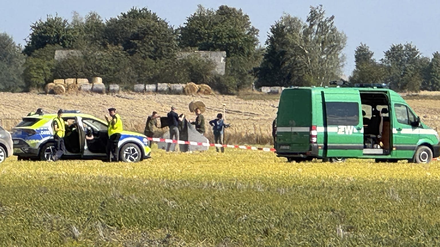 Rendőrök és katonai rendőrök biztosítják egy lelőtt drón részeit Wohynnál