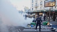 A police officer stands next to bins placed on a street to block it during the "Bloquons Tout" (Block Everything) protest movement in Paris, 10 September 2025