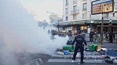 Ein Polizist steht neben den Mülltonnen, die während der Protestbewegung "Bloquons Tout" (Alles blockieren) in Paris am 10. September 2025 auf einer Straße aufgestellt wurden.