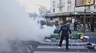 Un policier se tient à côté de poubelles placées dans une rue pour la bloquer lors du mouvement de protestation « Bloquons Tout » à Paris, mercredi 10 septembre 2025.
