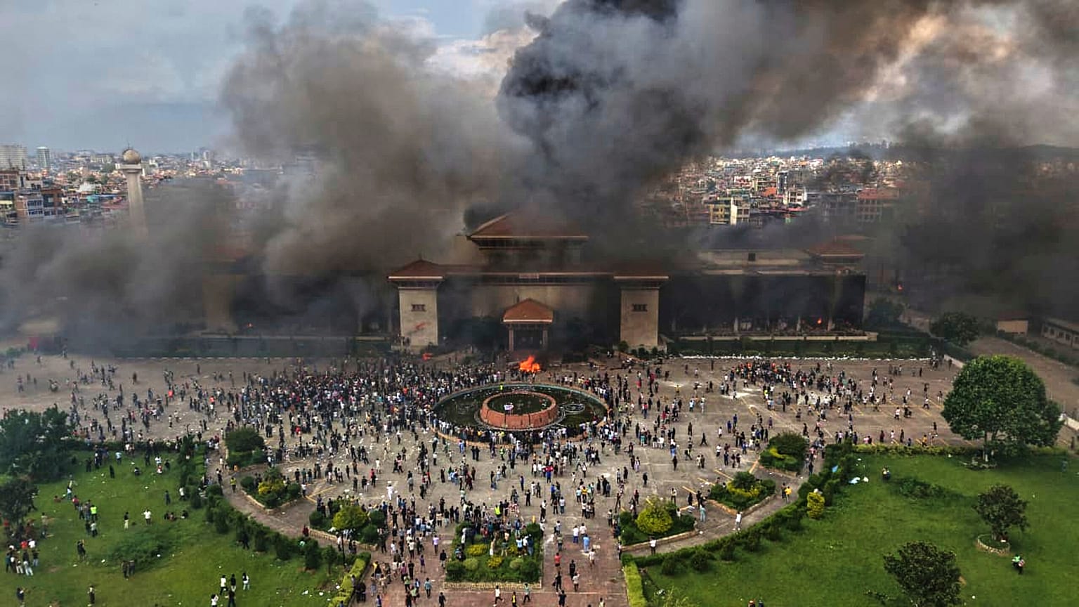 Protesters celebrate at the Singha Durbar after it was set on fire during a protest against social media ban and corruption in Kathmandu, Nepal, Tuesday, Sept. 9, 2025. 
