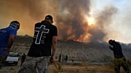 Residents gather to battle the fire at Omodos village during a massive wildfire on the southern side of the Mediterranean island, 24 July, 2025