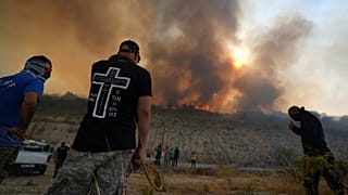 Residents gather to battle the fire at Omodos village during a massive wildfire on the southern side of the Mediterranean island, 24 July, 2025