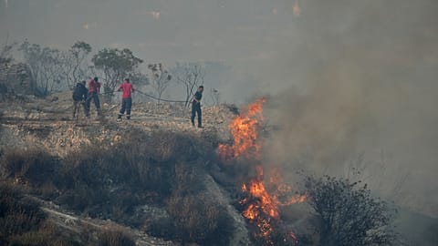 FILE: Residents try to extinguish the blazes in Omodos village, Cyprus, during a massive wildfire on the southern side of the island, 24 July 2025