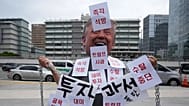 A demonstrator wearing a Donald Trump mask protests against the detention of South Korean workers during an immigration raid in Georgia, 9 September, 2025
