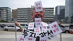 Um manifestante com uma máscara de Donald Trump protesta contra a detenção de trabalhadores sul-coreanos durante uma rusga de imigração na Geórgia, 9 de setembro de 2025