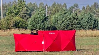 Os bombeiros protegem partes de um UAV danificado, abatido pelas autoridades polacas, num local em Czosnowka, perto de Biala Podlaska, na Polónia, quarta-feira, 10 de setembro de 2025.