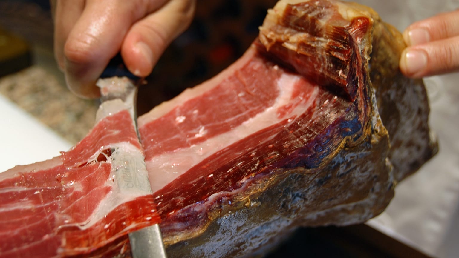 Archivo: Un hombre corta un jamón ibérico en Alburquerque, suroeste de España. 