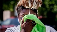 A woman wipes her face while setting up a drinks stand near the National Mall in Washington, US. 