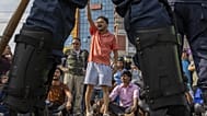 Tüntetők jelszavakat skandálnak rendőrsorfal előtt Katmanduban 2025. szeptember 9-én