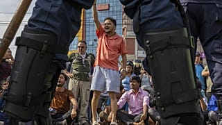 Tüntetők jelszavakat skandálnak rendőrsorfal előtt Katmanduban 2025. szeptember 9-én