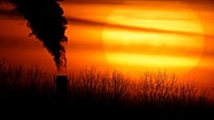 ARCHIVO - Las emisiones de una central eléctrica de carbón se recortan contra el sol poniente en Kansas City, Misuri, el 1 de febrero de 2021.