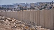 The separation wall next to the Arab neighbourhood of Al-Eizariya near where the Israeli government says housing units will be built as part of the E1 project, 21 August, 2025