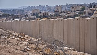 The separation wall next to the Arab neighbourhood of Al-Eizariya near where the Israeli government says housing units will be built as part of the E1 project, 21 August, 2025
