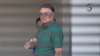 Brazil's former President Jair Bolsonaro flashes a thumbs up while standing at the entrance of his home where he is under house arrest, Brasilia, Brazil, Sept. 11, 2025