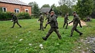 Polnische Territorialverteidigungsbeamte sammeln Trümmer vom zerstörten Dach eines Hauses, nachdem russische Drohnen den polnischen Luftraum verletzt hatten.