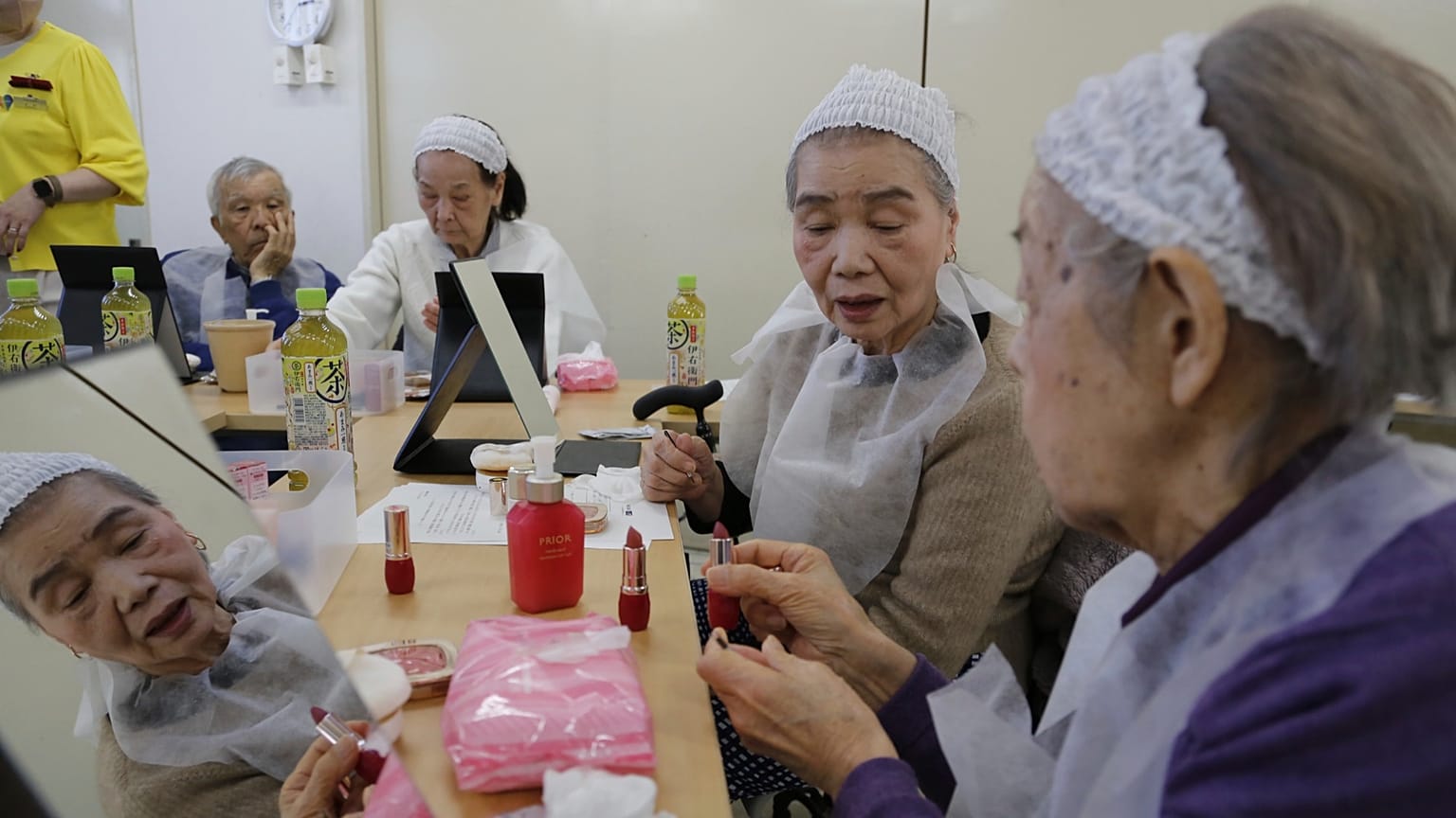 Older adults try on makeup at a special class at a Tokyo housing complex on Feb. 14, 2025.