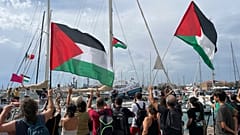 Menschen tragen palästinensische Flaggen, als sie sich von der italienischen Flotte der Global Sumud Flotilla verabschieden, die den Hafen von Siracusa, Italien, verlässt