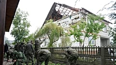 Soldados da Defesa Territorial retiram os destroços do telhado destruído de uma casa depois de drones russos terem violado o espaço aéreo polaco. 11.09.2025