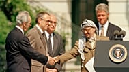 رئيس منظمة التحرير الفلسطينية ياسر عرفات يصافح وزير الخارجية الإسرائيلي شيمون بيريز، على اليسار في البيت الأبيض في واشنطن العاصمة، الاثنين 13 سبتمبر/ أيلول 1993.