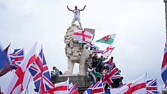 Ein Demonstrant steht auf dem Kopf eines der Löwen auf der Westminster Bridge während eines von Tommy Robinson angeführten Marsches und einer Kundgebung von Unite the Kingdom in London, Samstag, 13. September 2025.