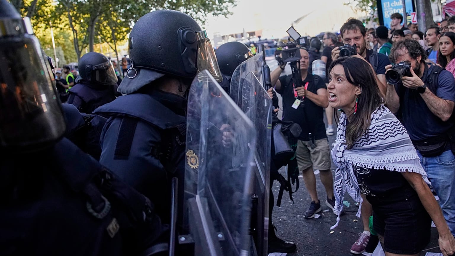 متظاهرة تتجادل مع الشرطة بينما يحاولون تعطيل المرحلة الحادية والعشرين من سباق الدراجات الإسباني "لا فويلتا"، من ألالباردو إلى مدريد، إسبانيا، الأحد، 14 سبتمبر/أيلول 2025