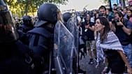 متظاهرة تتجادل مع الشرطة بينما يحاولون تعطيل المرحلة الحادية والعشرين من سباق الدراجات الإسباني "لا فويلتا"، من ألالباردو إلى مدريد، إسبانيا، الأحد، 14 سبتمبر/أيلول 2025