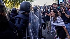 متظاهرة تتجادل مع الشرطة بينما يحاولون تعطيل المرحلة الحادية والعشرين من سباق الدراجات الإسباني "لا فويلتا"، من ألالباردو إلى مدريد، إسبانيا، الأحد، 14 سبتمبر/أيلول 2025