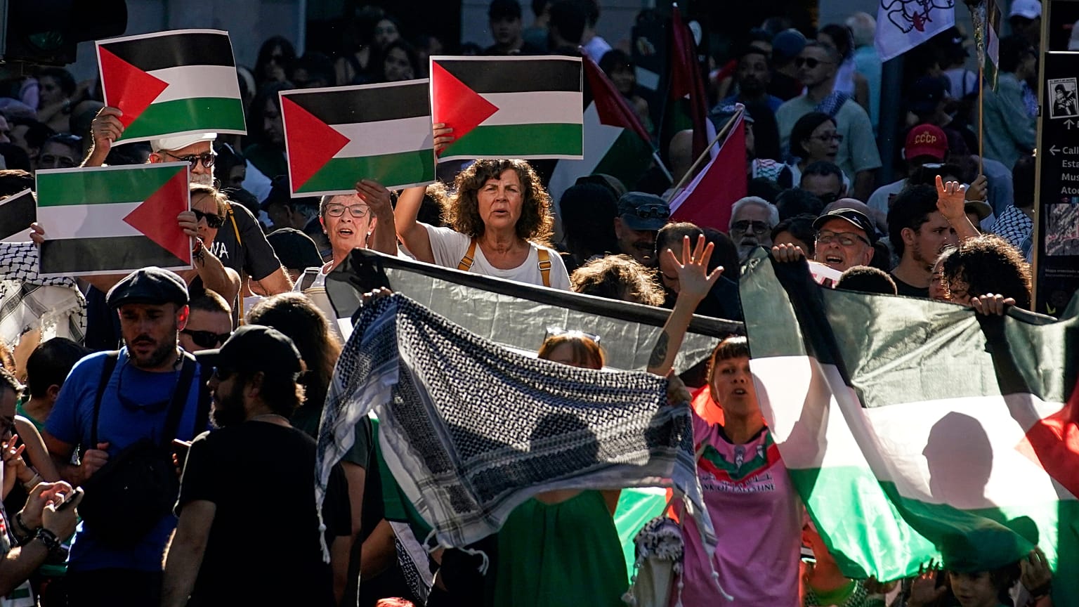 Des gens crient des slogans et brandissent des drapeaux palestiniens lors d'une manifestation