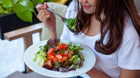 A woman eats a salad.