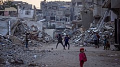 Palästinensische Kinder spielen neben Gebäuden, die durch israelische Armeeangriffe zerstört wurden.