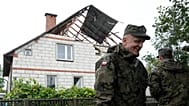 Territorial defence officers stand near a damaged house after Russian drones violated Polish airspace during an attack on Ukraine, 11 September, 2025