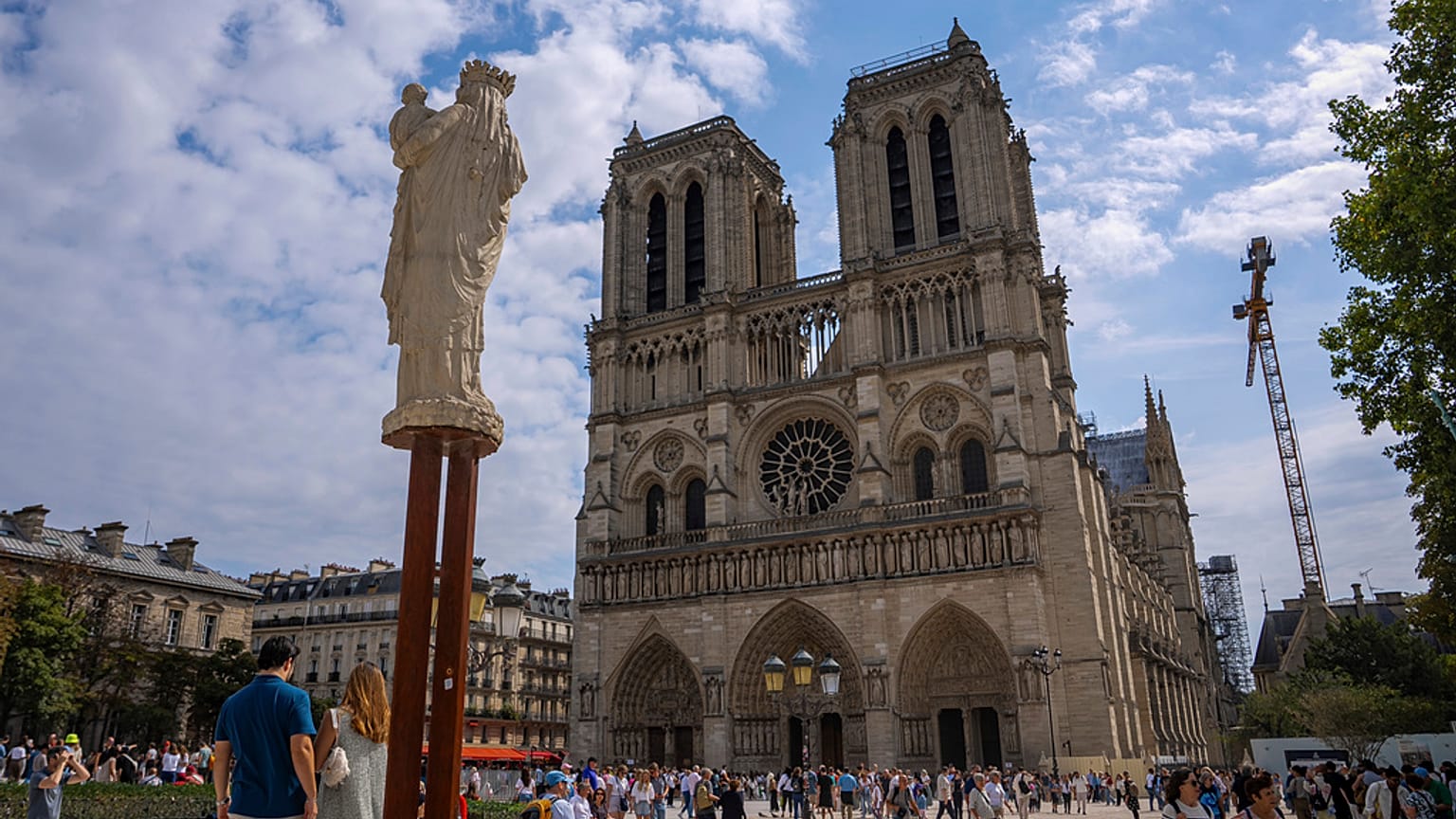 People walk on the forecourt of Notre Dame Cathedral in Paris, 21 August 2025.