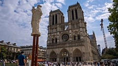 Menschen gehen auf dem Vorplatz der Kathedrale Notre Dame in Paris, 21. August 2025.